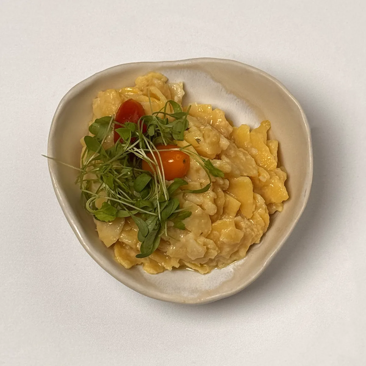Kartoffelsalat im Keramikschälchen mit Kresse und Kirschtomaten