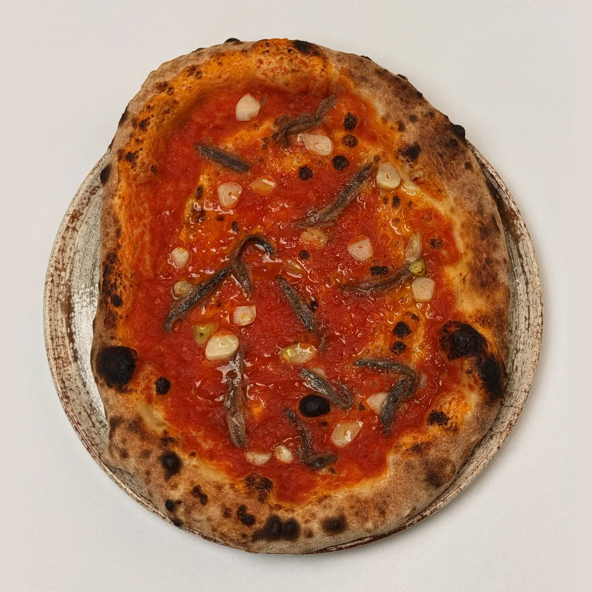 Pizza Marinara mit Tomatensoße, Knoblauchzehen und Sardellen