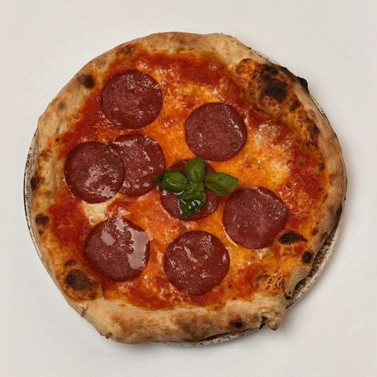 Pizza Salami mit Tomatensoße, Mozzarella, Salamischeiben und Basilikum