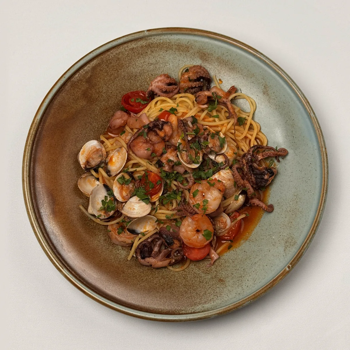 Spaghetti allo Scoglio mit Venusmuscheln, Garnelen, kleinen Pulpo, Kirschtomaten und Petersilie