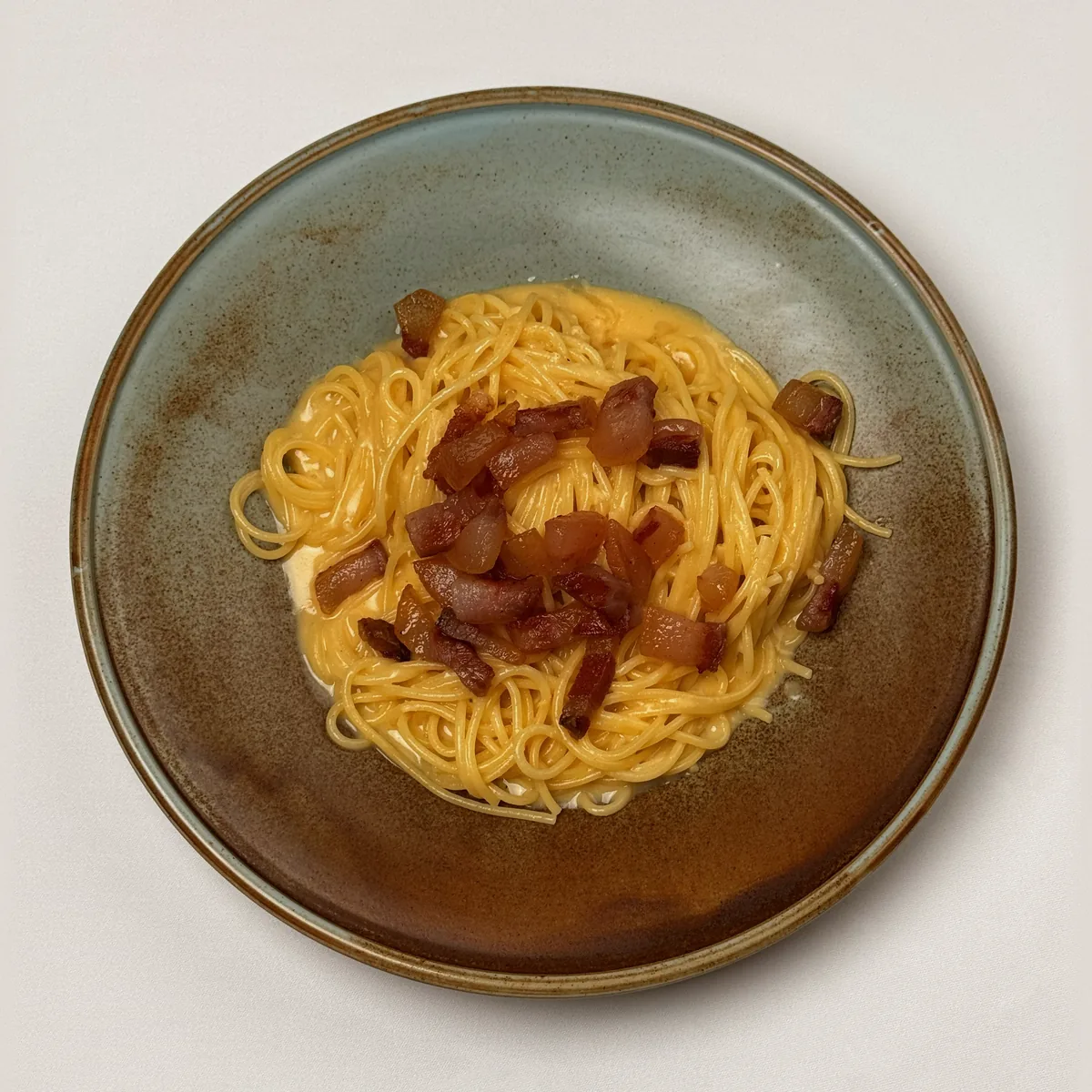 Spaghetti Carbonara in cremiger Eigelbsoße mit gebratenen Guanciale-Würfeln